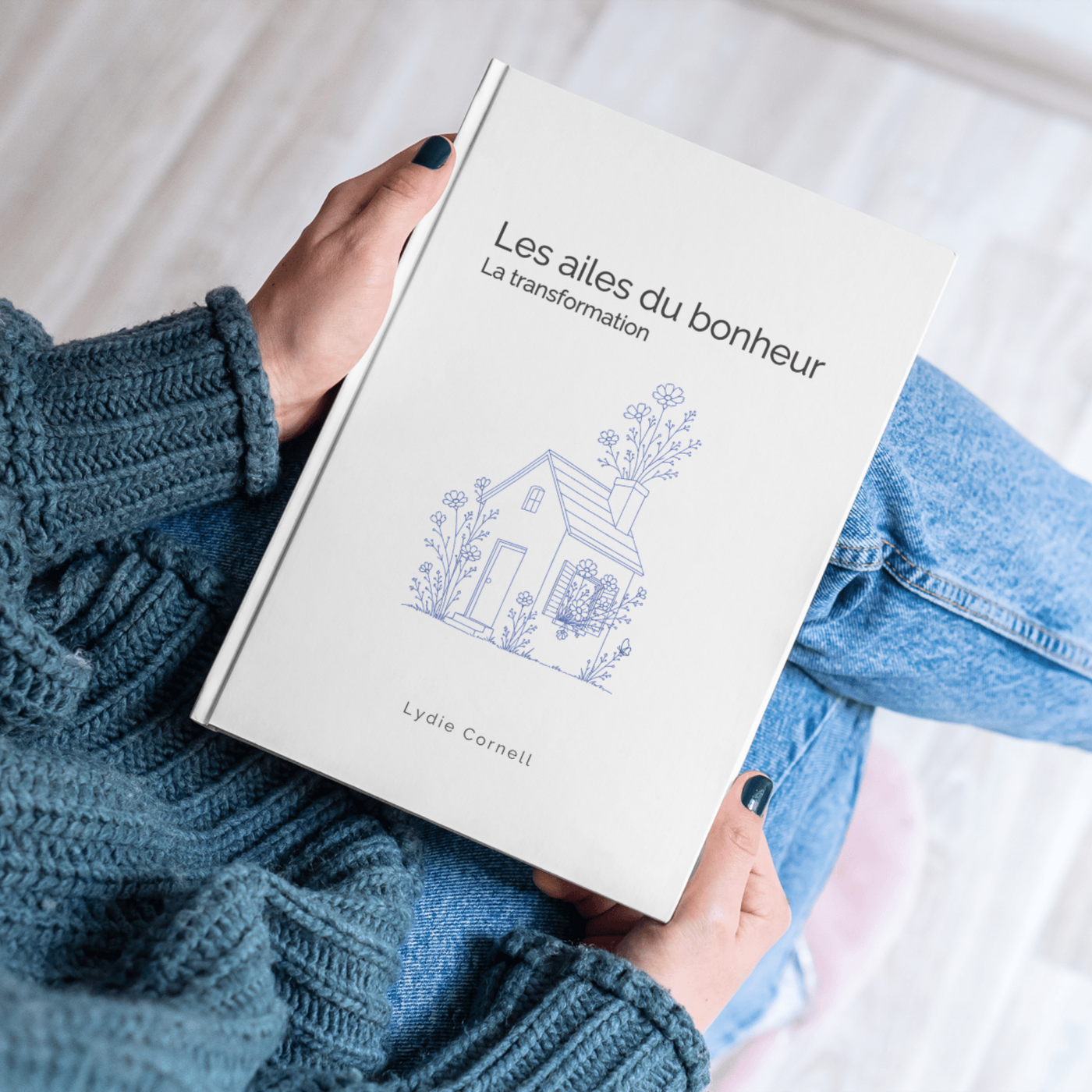 Des mains tenant le livre Les ailes du bonheur de Lydie Cornell